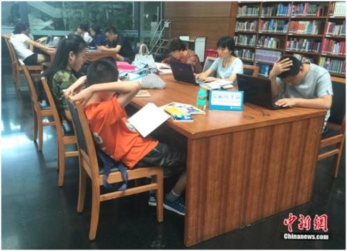 资料图：图书馆内部门儿童正认真阅读，一旁标识提醒读者保持安静。杨雨奇 摄